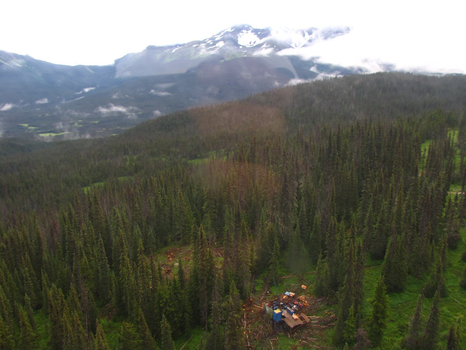Aerial view of an exploration drill site in a forest clearing at the Zymo property, with drilling equipment visible